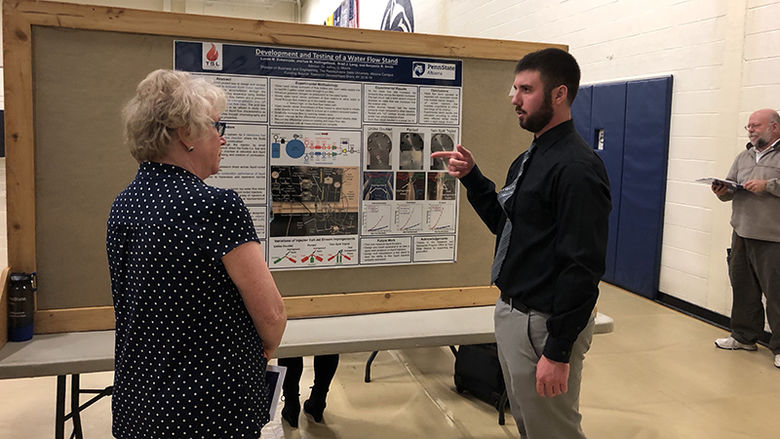 A student presenter chats with an attendee