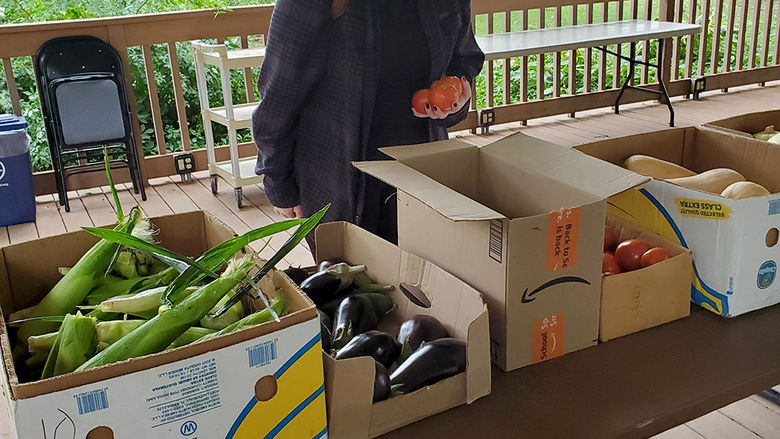 Student checks out produce at the farmer's market