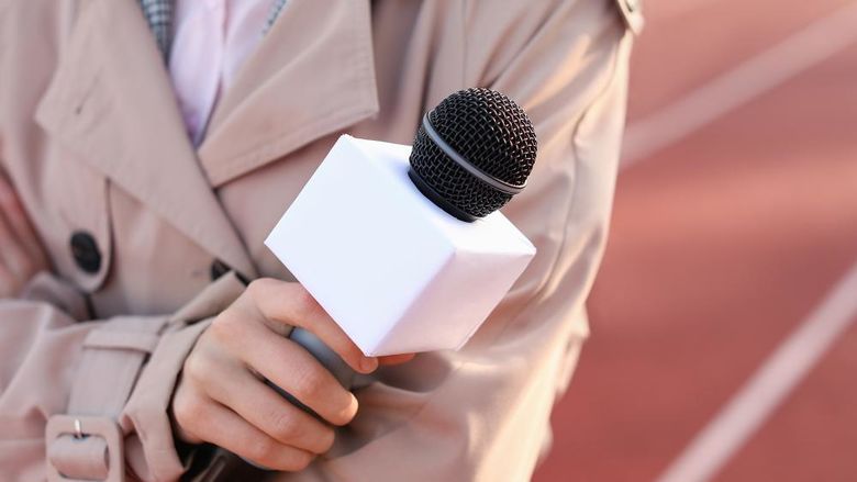 a female sports reporter holding a microphone