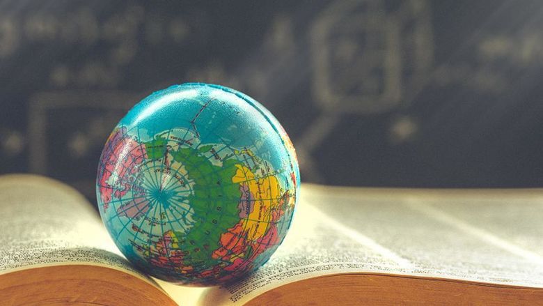 A small globe sitting on top of a book