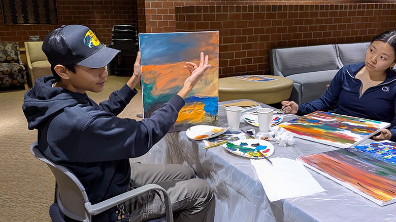 Azeem Moussa explaining his art work inspired by Heidi Manfred's guidance