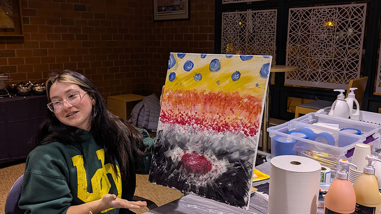 Caitlin Blessel showcasing her painting inspired by Heidi Manfred's guidance