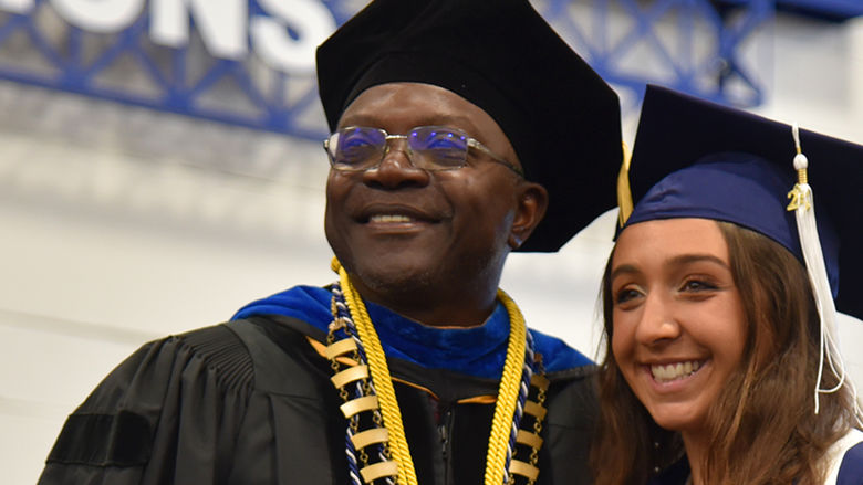 Penn State Altoona Chancellor Ron Darbeau poses for a photo with a graduate during the spring 2025 commencement ceremony