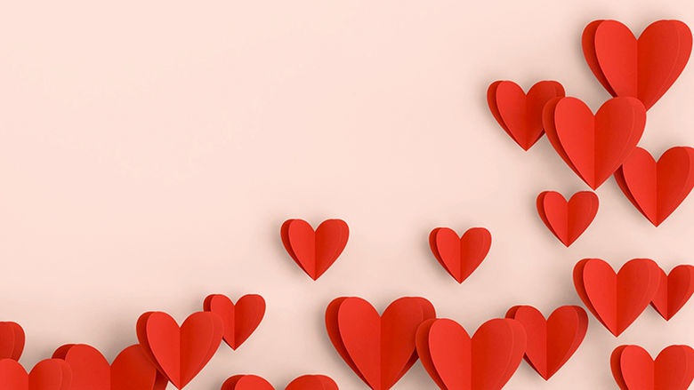 Red paper hearts on a pink background