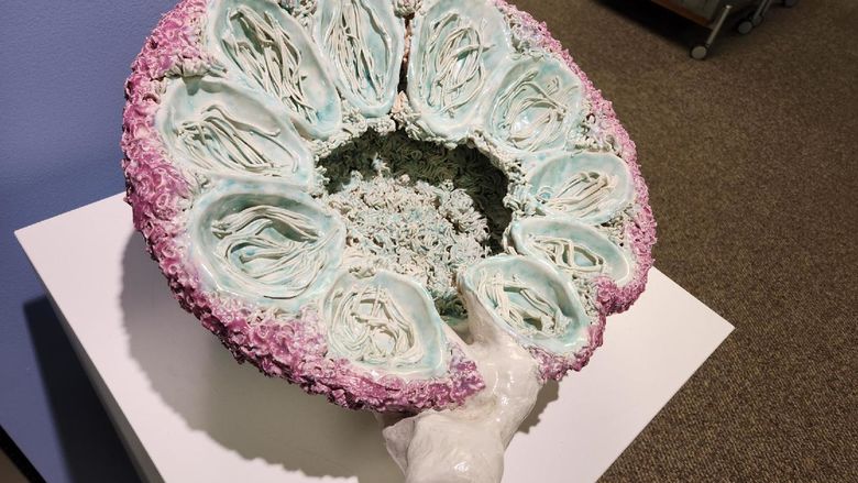 Ceramic sculpture, shaped like half of a circle with multiple holes in the structure.