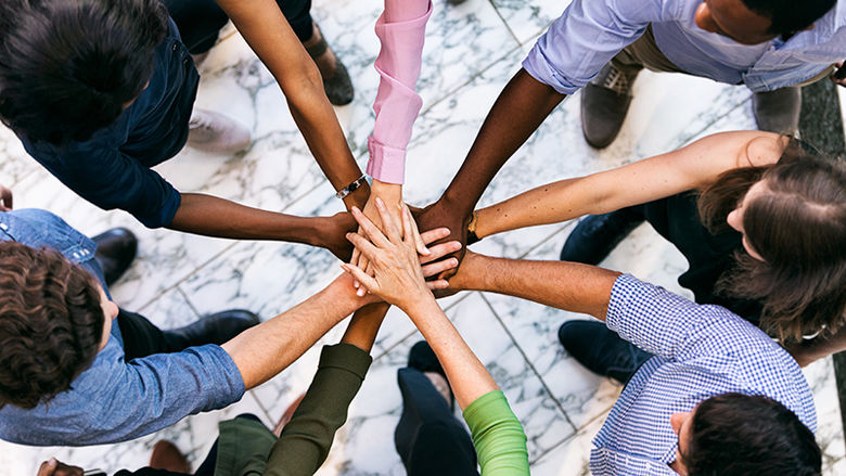 Diverse group of people with hands in the middle