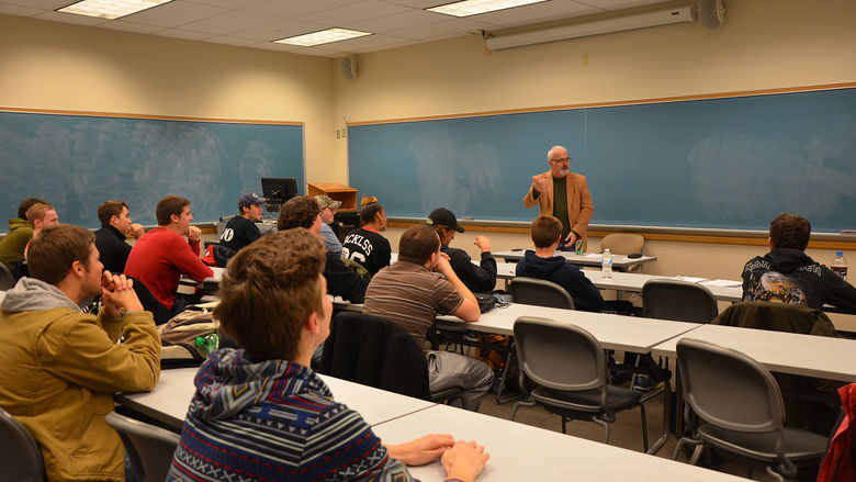 Communications Professor Bill White teaching a classroom full of students