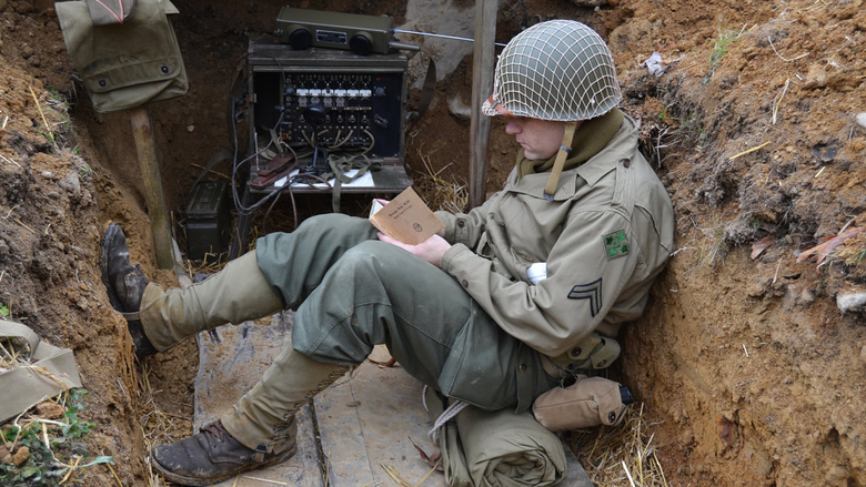 A WWII reenactor dressed as a soldier in a trench