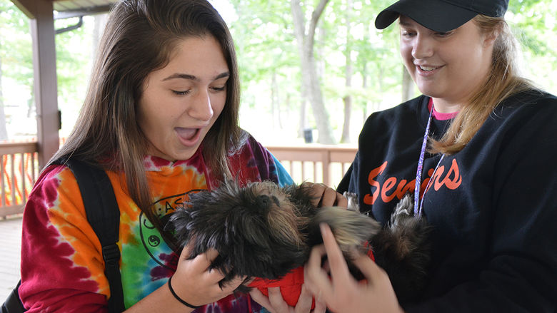 Penn State Altoona students hugging a puppy