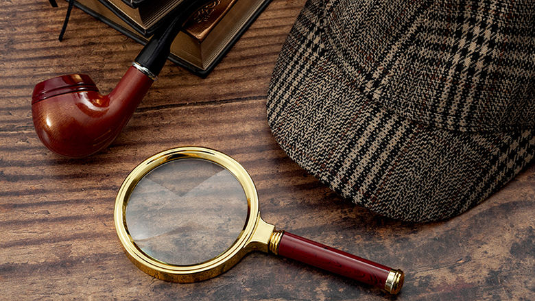 Sherlock Holmes magnifying glass, cap, pipe, and books