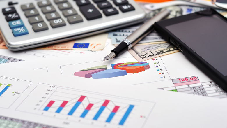 Accounting stock photo including charts, calculator, pen, and mobile phone