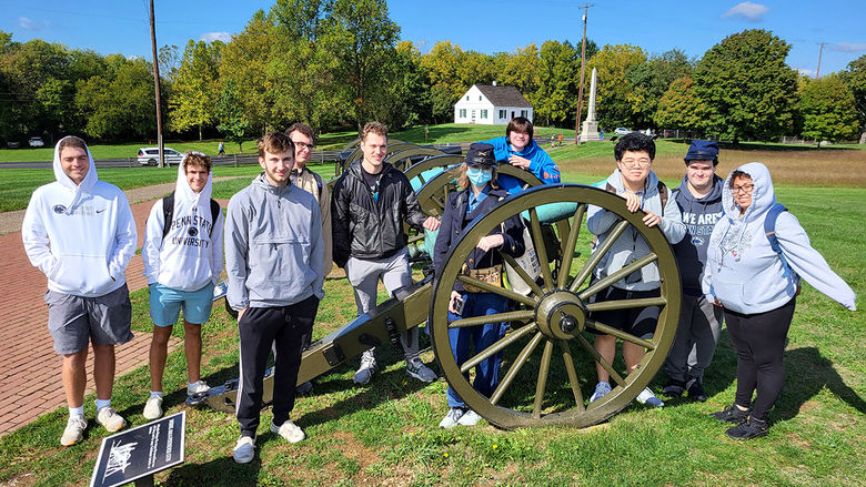 Penn State Altoona history students pose for a photo around a cannon at the Antietam battleground site