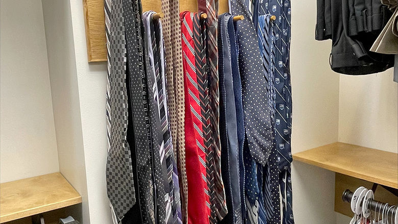 A wall-mounted rack of various neckties