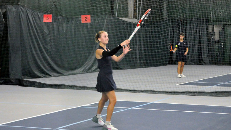 Penn State Altoona student-athlete Lexi Colaianni playing tennis in an indoor facility.