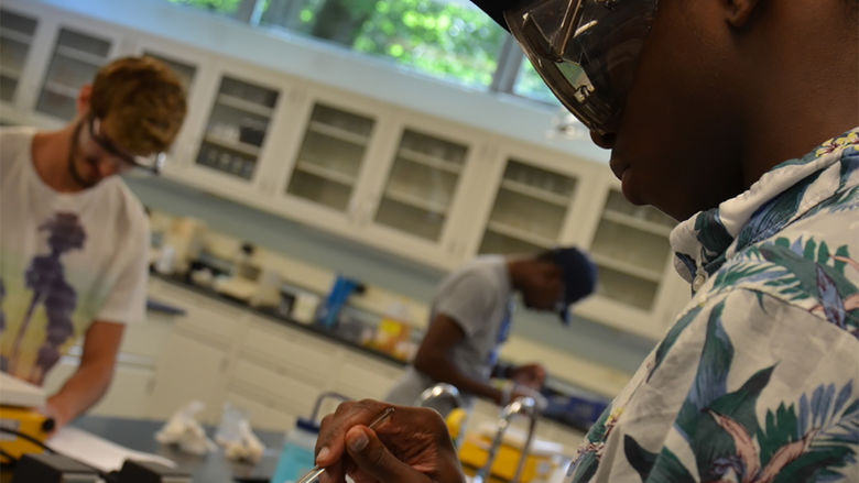 Students work in a chemistry lab on campus