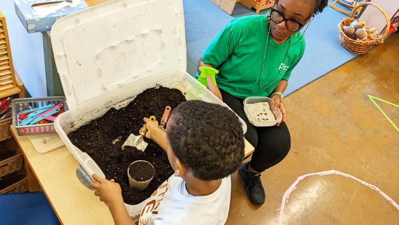 Chastity Bey helps a child plant seeds during a school program