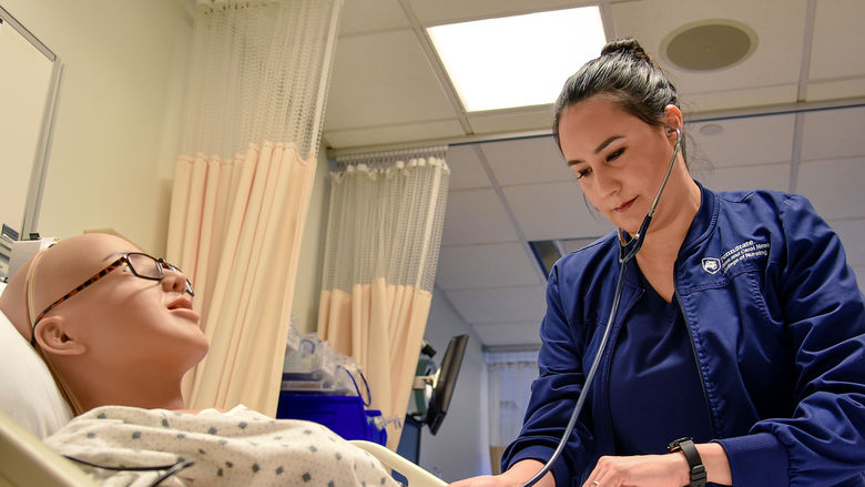 Paola Jaramillo Calderon interacts with a mannequin in Penn State Altoona's nursing simulation lab.