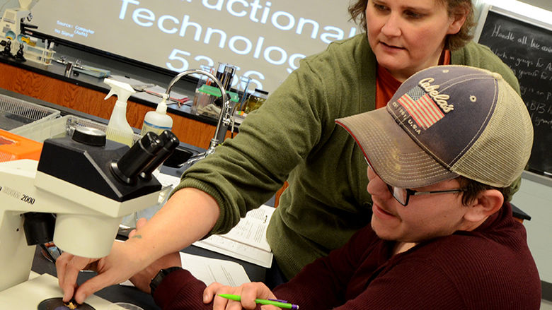 Palmer assists a student during a lab exercise in her Biology 110 course.