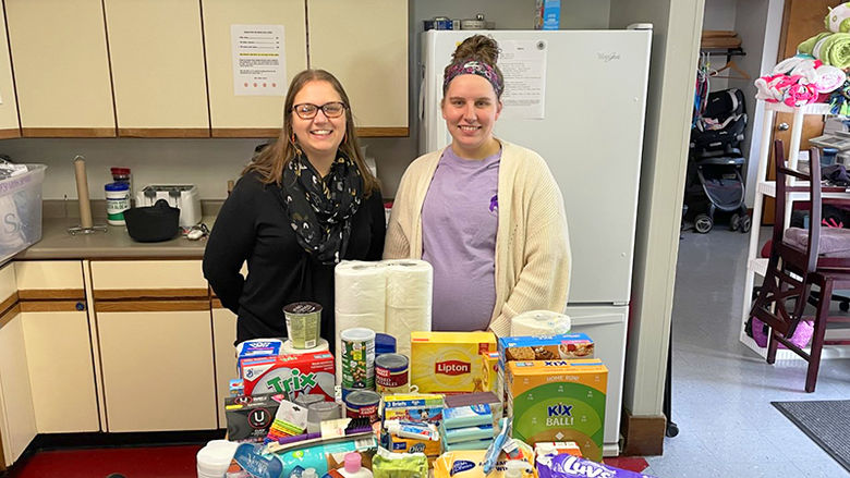 Alicia Williams (R) and Ashley Gay-Vocco, director of Family Services Incorporated Victim Services Program, with items collected during Domestic Violence Awareness Month activities.