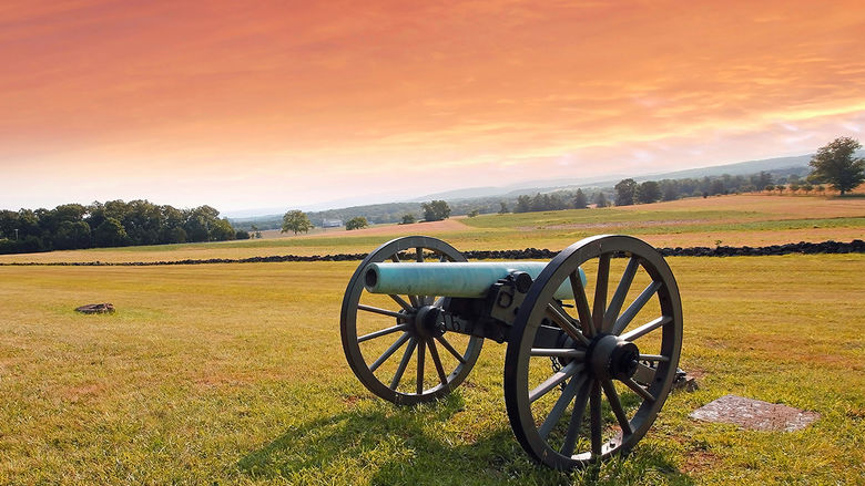 A Civil War era cannon sitting in the middle of a field at Gettysburg