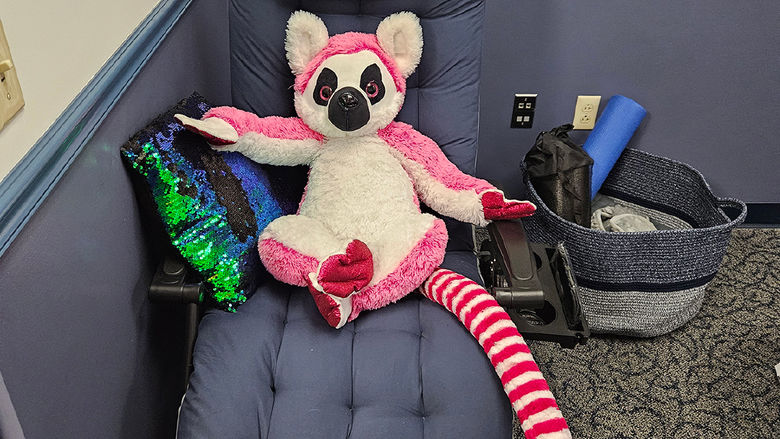 a blue gravity chair with a pink stuffed animal sitting on it