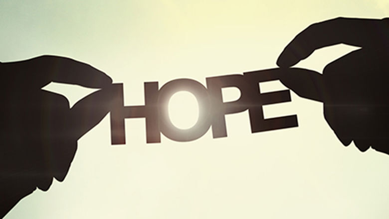 Two hands holding a paper cutout that reads HOPE