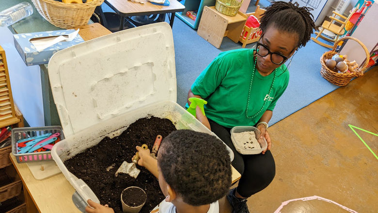 Chastity Bey helps a child plant seeds during a school program