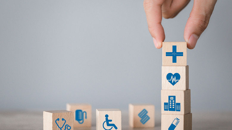 Stacking wooden blocks that represent different aspects of health professions