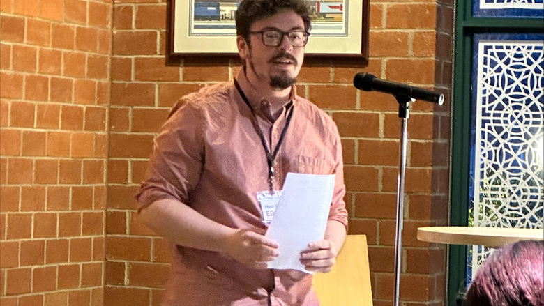 Aidan Pellegrino, Editor-in-Chief of Hard Freight, welcomes the audience.