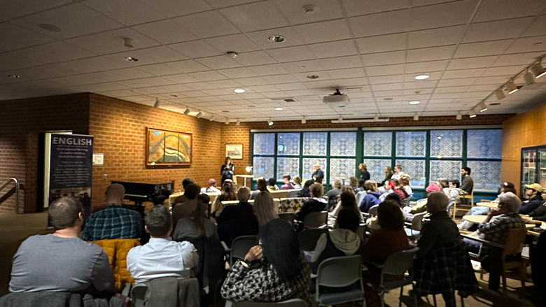 The crowd listens to Lee Peterson read her poetry.