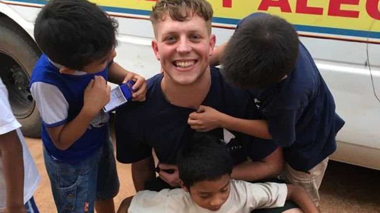 Dalton Godfrey poses with children moments after getting off the bus