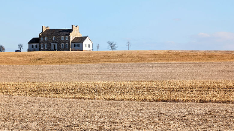 An old farmhouse in the middle of a field