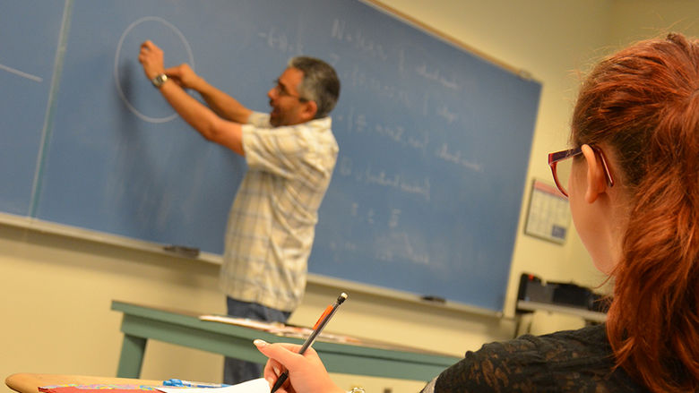 A student looks on as Juan Gil teaches