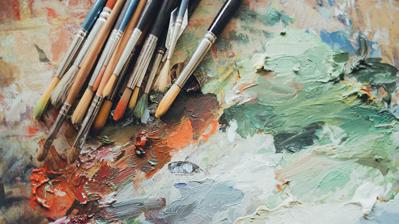 Paintbrushes on a paint-covered board