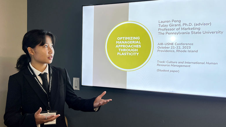 Person in front of a monitor displaying a powerpoint