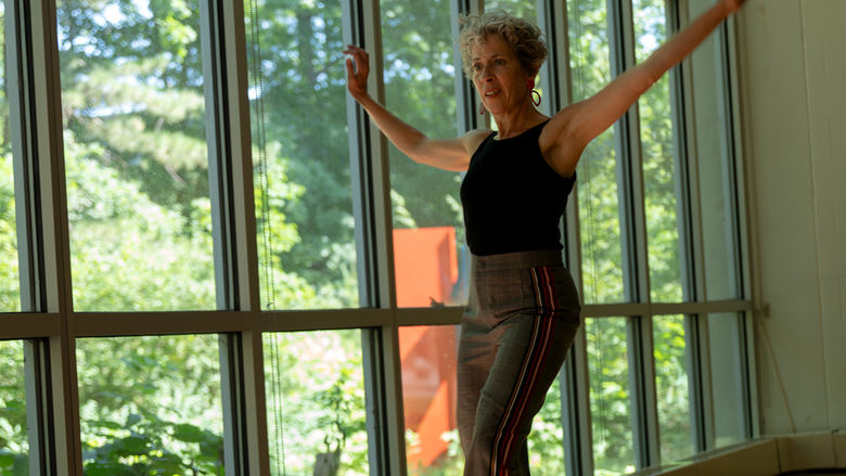 Michele Dunleavy dances in a dance studio in front of windows