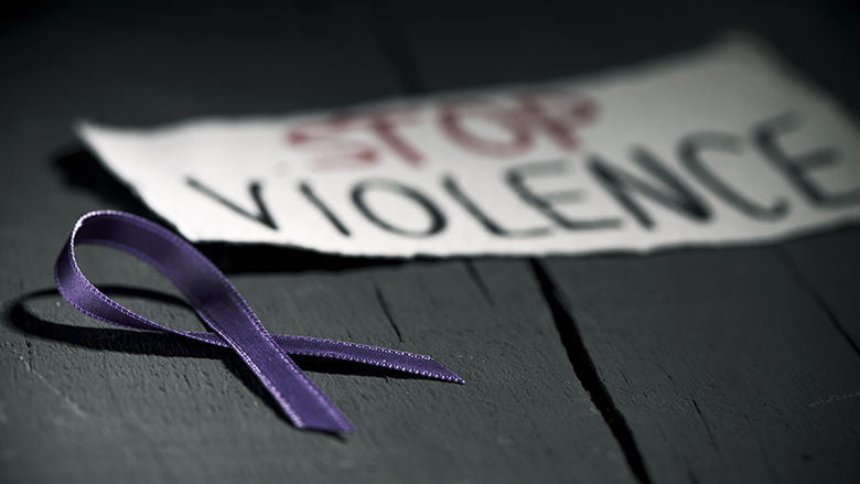 a purple ribbon and a sign reading Stop Violence