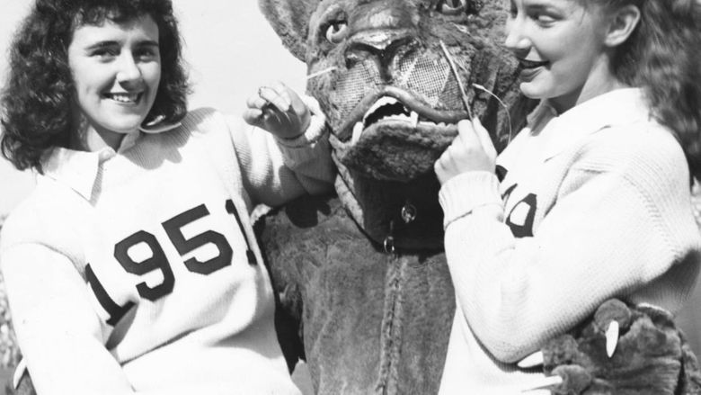 The Nittany Lion poses with two female cheerleaders in 1951.