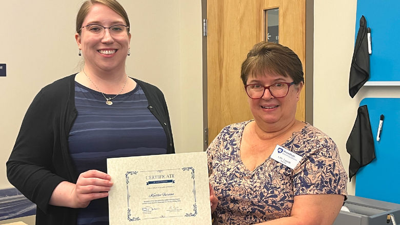 Kaitlin Farnan (L) is presented with an award certificate by Lori Lysiak, reference and instruction librarian at Eiche Library.