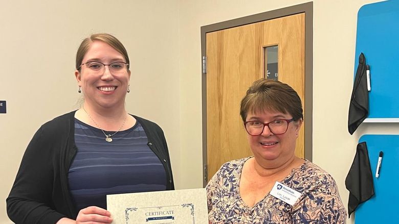 Kaitlin Farnan (L) is presented with an award certificate by Lori Lysiak, reference and instruction librarian at Eiche Library.