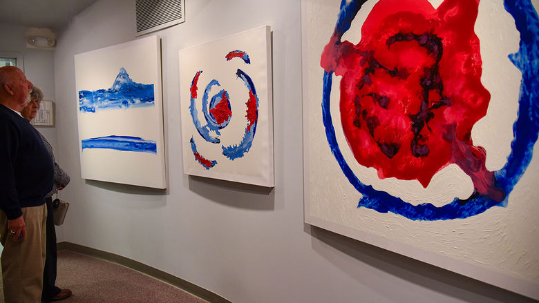 Community members take in the pieces from Heidi Manfred’s Emotions in Art exhibit at the Oct. 28 opening. 
