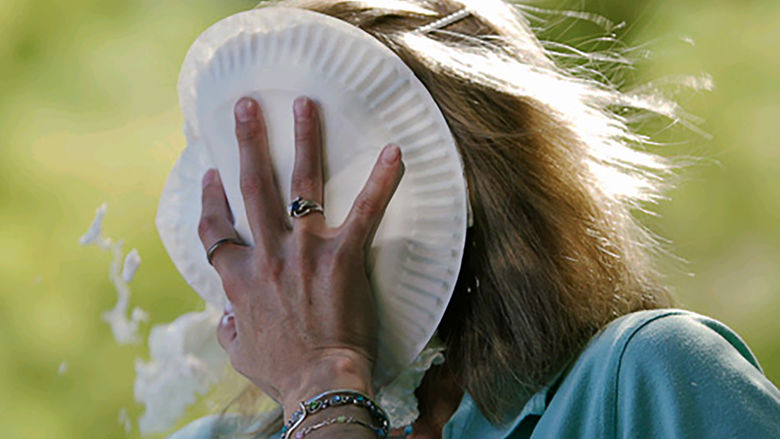 A woman with a plate of whipped cream in her face