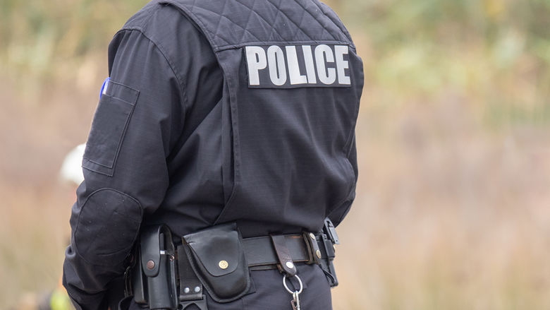 A police officer in uniform facing away from the camera