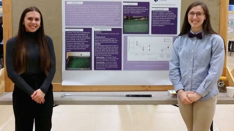 Leah Gitto and Kierra Irwin with their poster at the Undergraduate Research and Creative Activities Fair