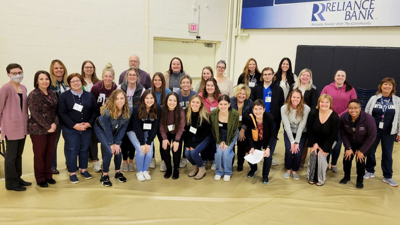 Student and faculty pose for a photo following a poverty simulation exercise at Penn State Altoona