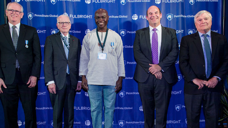 Associate Professor Kofi Adu poses for a photo with Penn State administrators at a celebration of the 75th anniversary of the Fulbright program