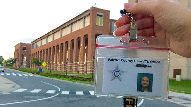 Alexis Puz displays her internship ID in front of the Fairfax County Sherrif's Office