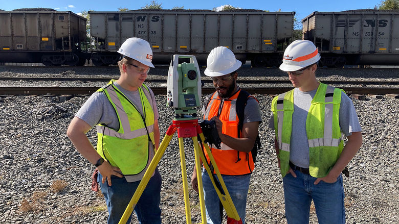 (L-R) Students Gary Babcoke, Malique Qualls, and Evan Noll learn to use a SafeLoad laser device by Leica Geosystems on Norfolk Southern's Rose Yard in Altoona in fall 2022.