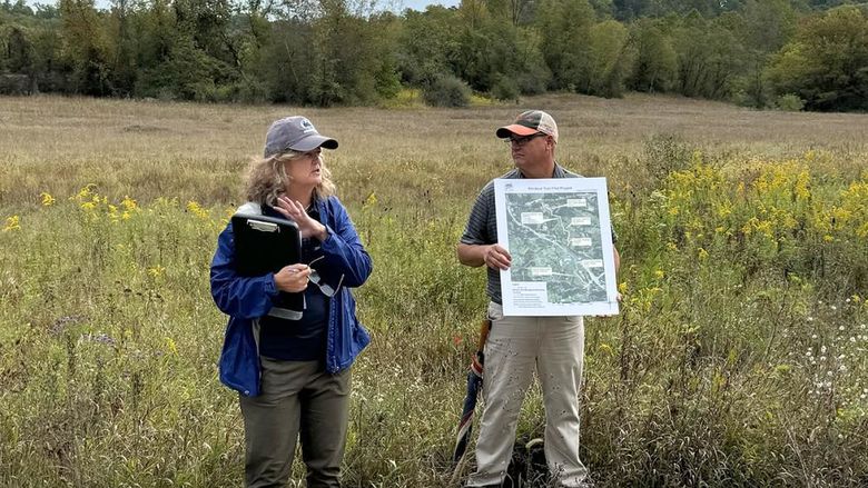 Two people stand in a field