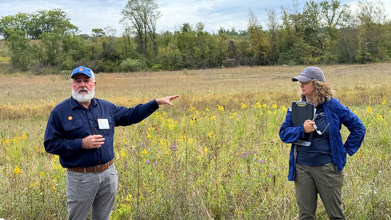 Two people stand in a field